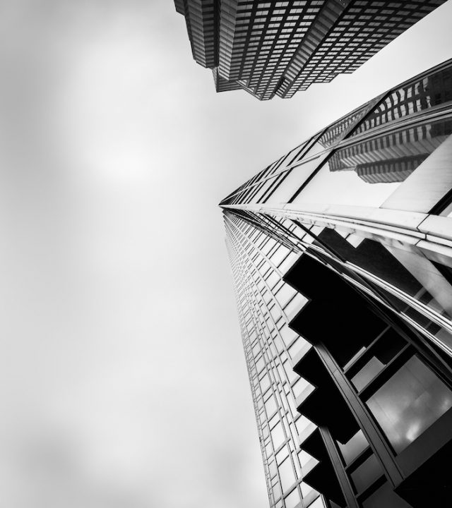 A greyscale low angle shot of high-rise buildings in the financial district of Toronto Canada under the cloudy sky